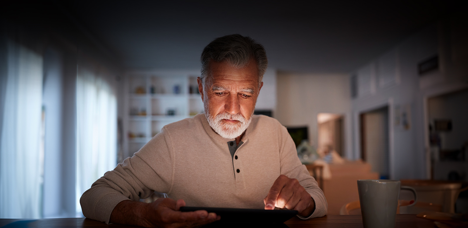 man holding tablet in low lighting