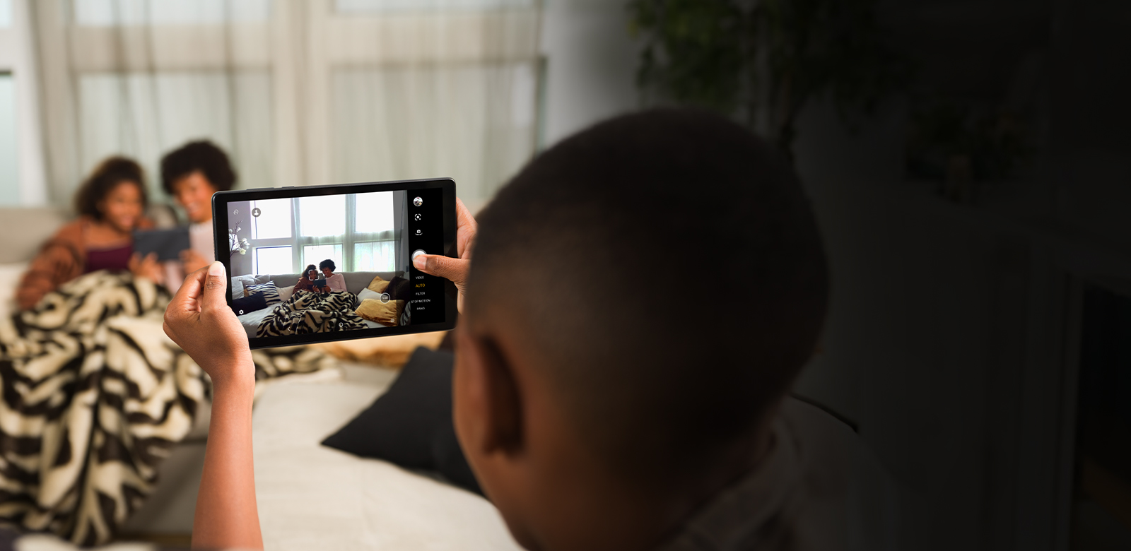 child taking photo of family with tablet rear camera